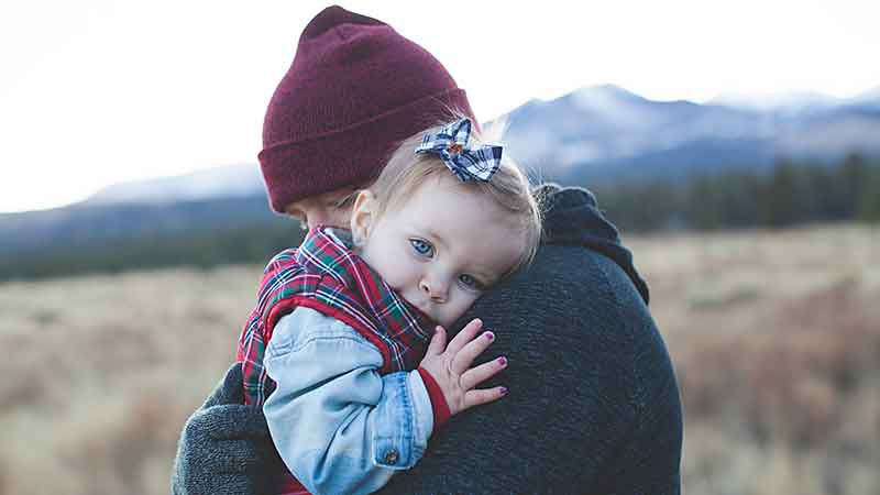 toddler snuggled into her daddy's shoulder