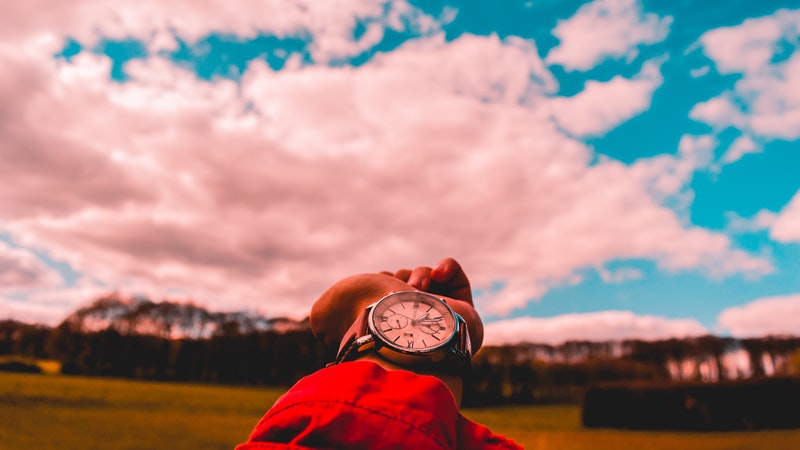 out stretched hand, face of watch toward sky