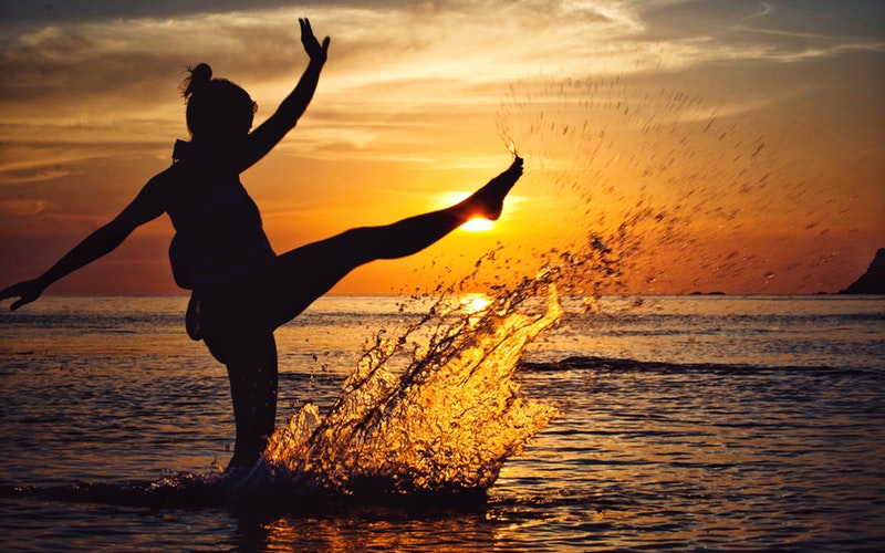 woman beach sunset kicking water