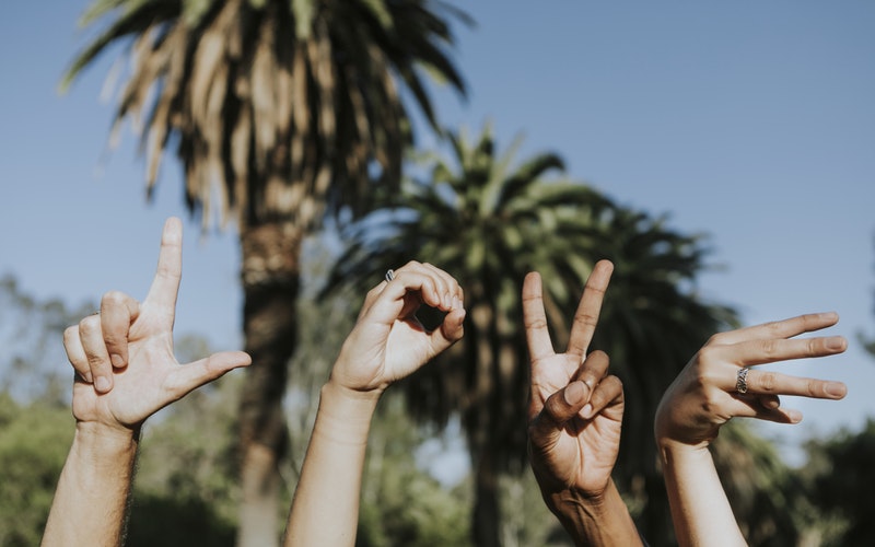 Hands in the air spelling LOVE with fingers