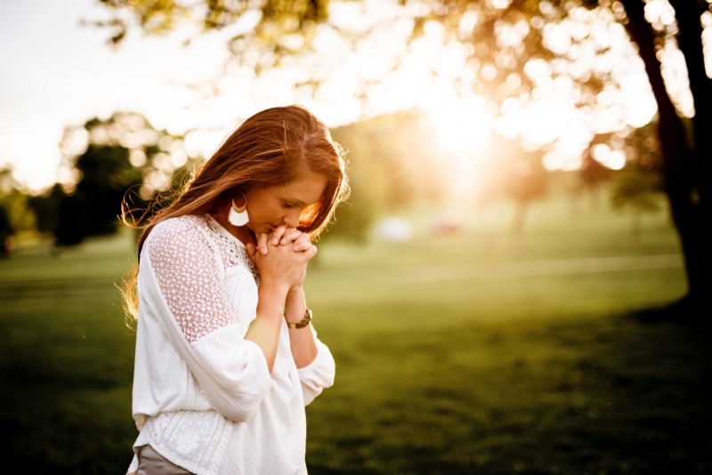 woman praying in park