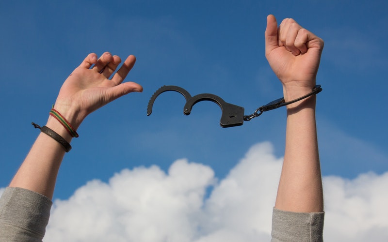 person's hands in the air with handcuff breaking away from one wrist. Finish Line.