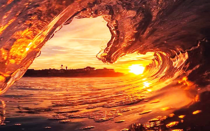 sunset peeking through breaking wave