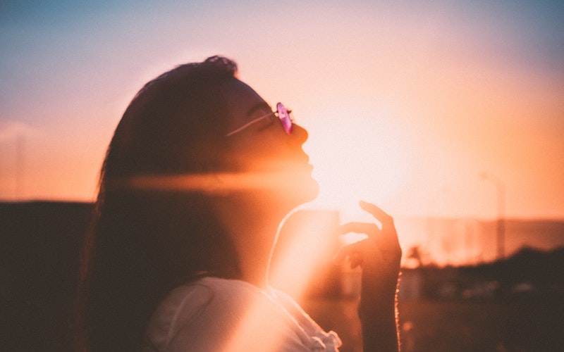 woman yielding to sunlight on face