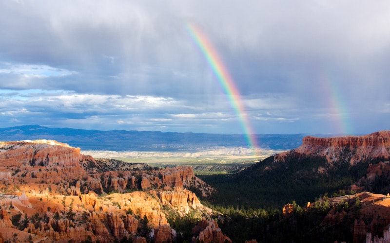 double rainbow over valley