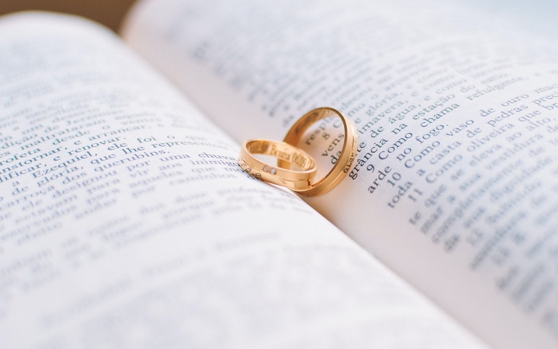 Insatiable Love, Blog Post, Holy Bible in Spanish opened with a man and woman's wedding rings resting in the open spine of the book.