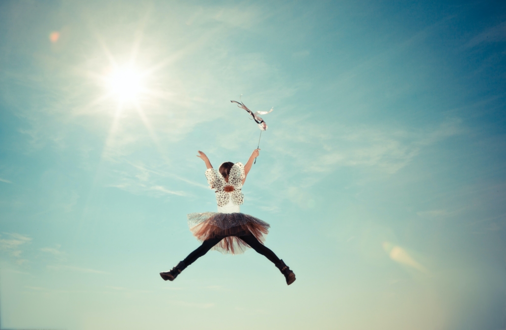 girl in tights, tutu and holding wand over her head jumping high in the air, new beginnings