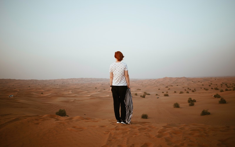 Woman facing away looking across the desert, blog post Confident