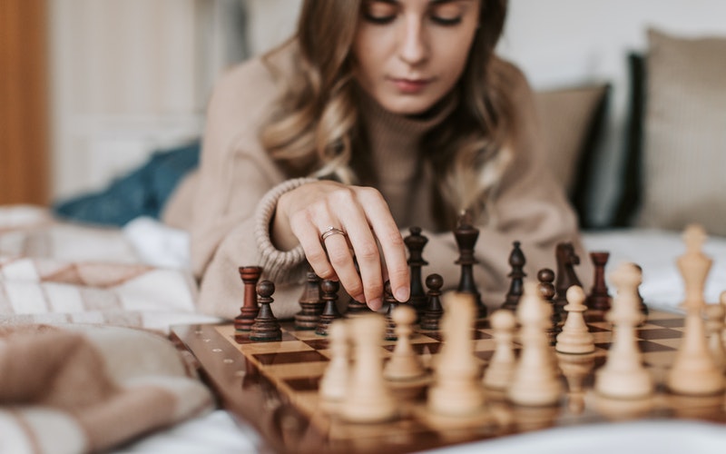 young woman playing the board game chess, Life is Like a Board Game blog post