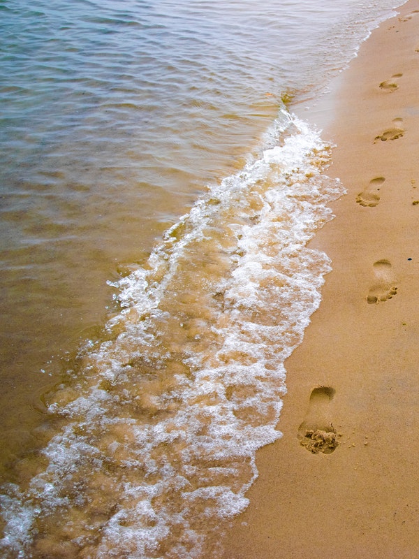 The Good God Blog Post - shore line at the beach with footprints in the sand