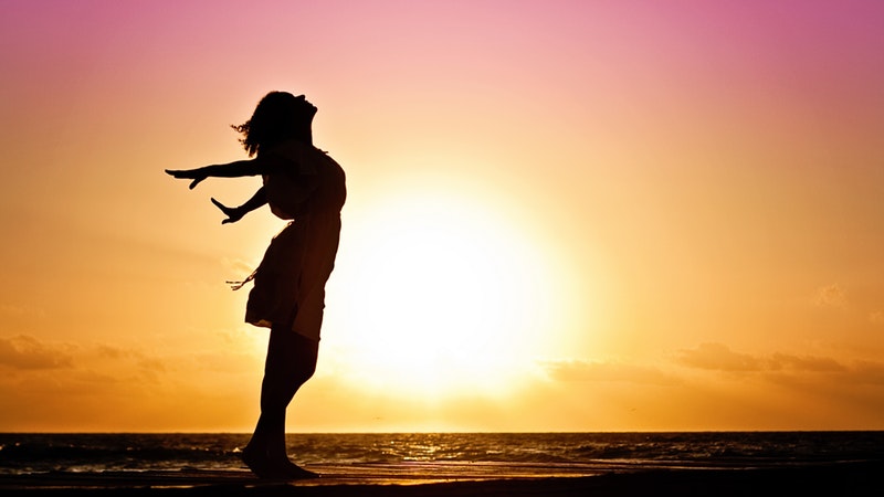 woman on beach looking heavenward