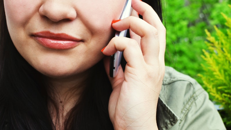 close up woman's face talking on cell phone