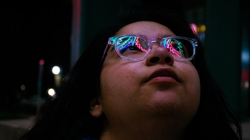 Woman looking up at neon lights